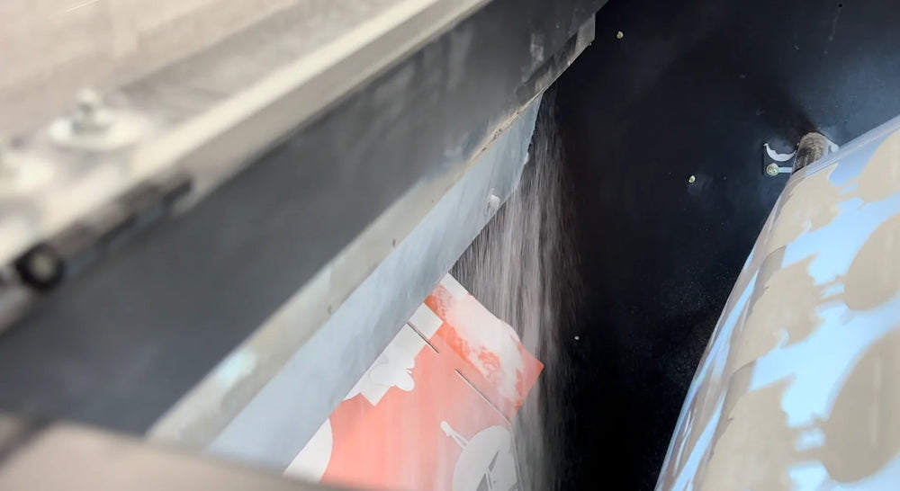 Adhesive powder falling onto freshly printed DTF transfer film.